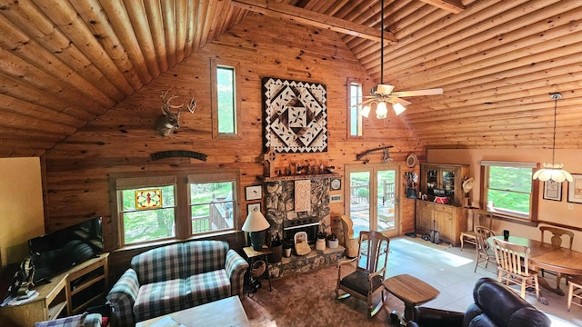 living area with wood ceiling, high vaulted ceiling, plenty of natural light, wood walls, and ceiling fan