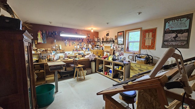 miscellaneous room with a workshop area and finished concrete flooring