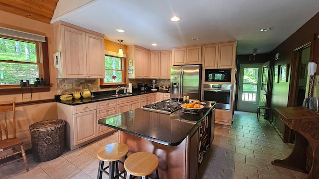 kitchen featuring appliances with stainless steel finishes, a sink, plenty of natural light, tasteful backsplash, and recessed lighting