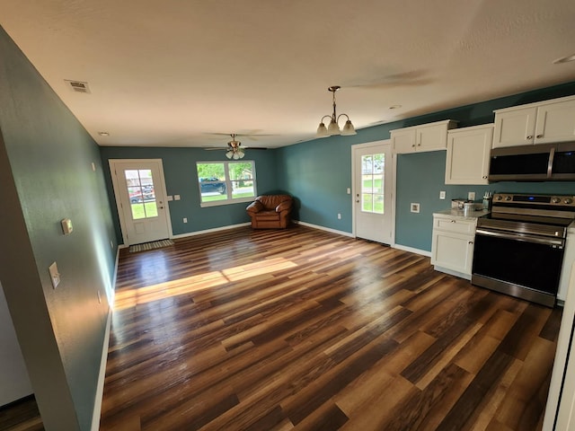 kitchen featuring stainless steel appliances, dark wood-type flooring, white cabinets, open floor plan, and baseboards