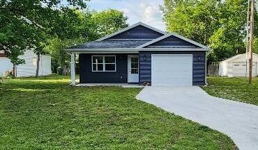 ranch-style home with an attached garage, a front yard, and driveway