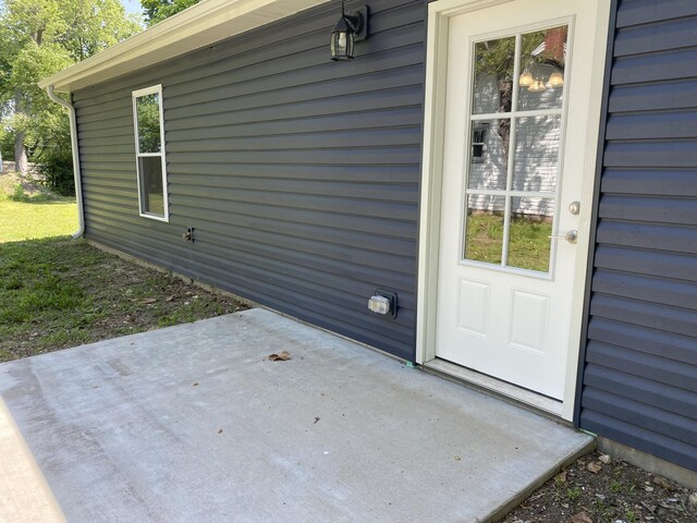 view of exterior entry with a patio area