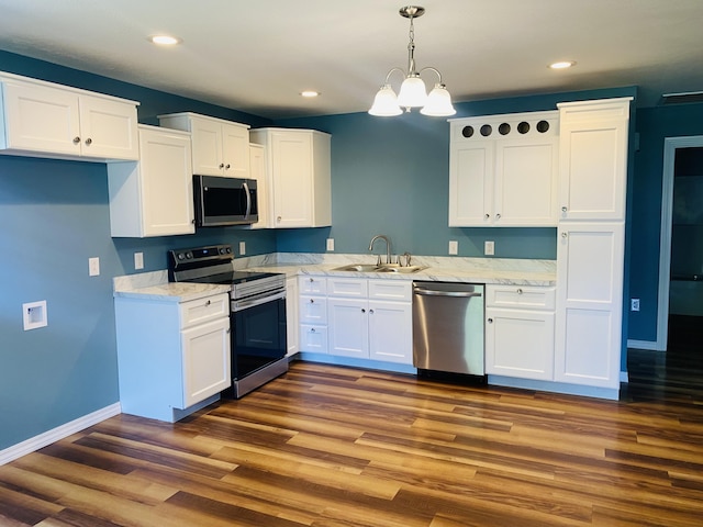 kitchen featuring appliances with stainless steel finishes, a sink, white cabinets, and recessed lighting
