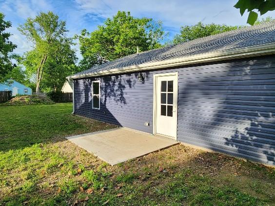back of house with a patio and a yard