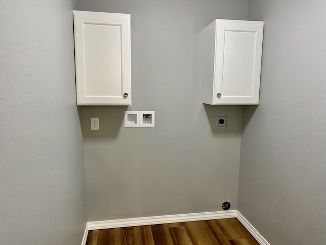 clothes washing area with electric dryer hookup, hookup for a washing machine, cabinet space, baseboards, and dark wood-type flooring