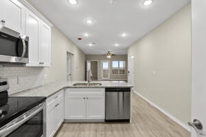 kitchen featuring stainless steel appliances, a peninsula, recessed lighting, tasteful backsplash, and a sink