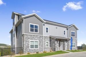 view of front of house with stone siding and fence