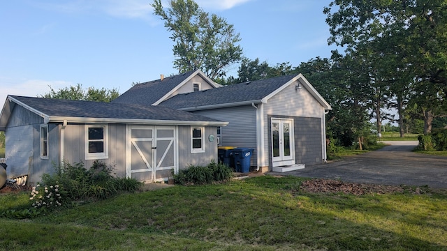 636 W Center St, Rogersville, MO 65742 - rear view of property featuring a yard, a shingled roof, an outdoor structure, and driveway