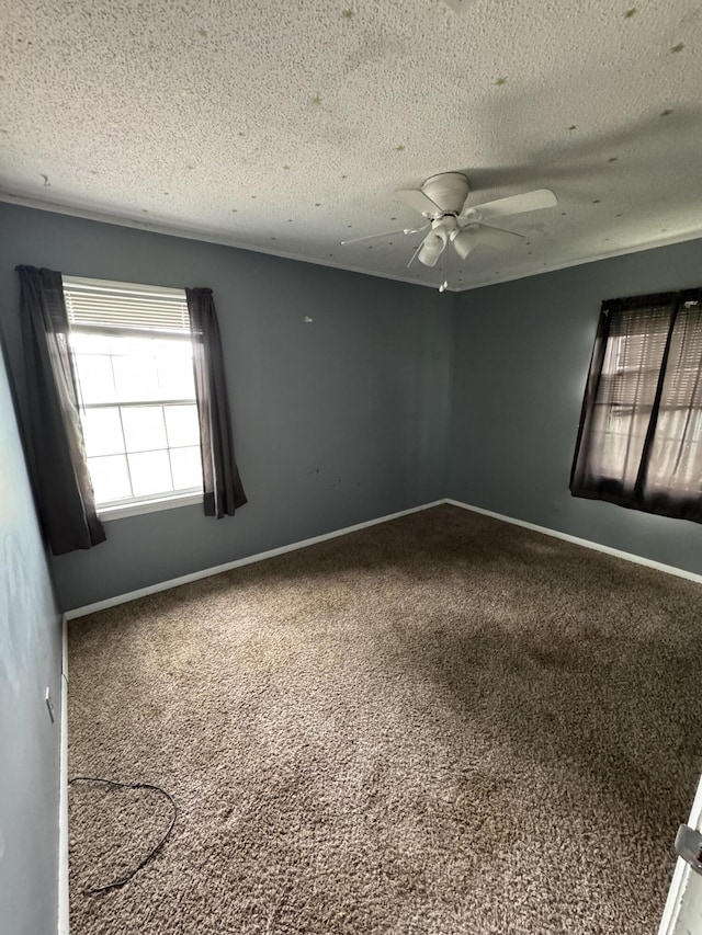empty room with carpet, a textured ceiling, ceiling fan, and baseboards