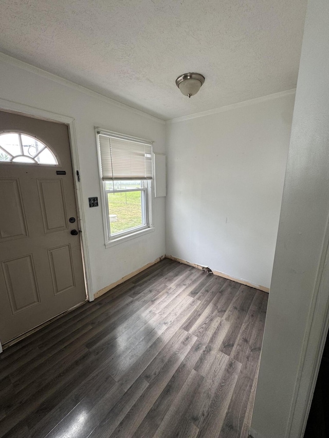 foyer featuring a textured ceiling, dark wood-style flooring, and crown molding