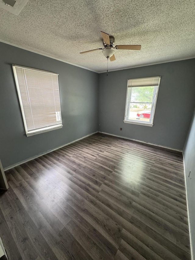 empty room with a textured ceiling, a ceiling fan, wood finished floors, and baseboards