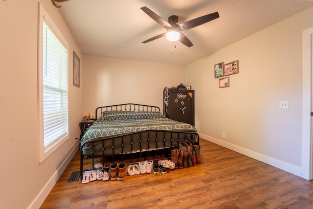 bedroom with baseboards, wood finished floors, and ceiling fan