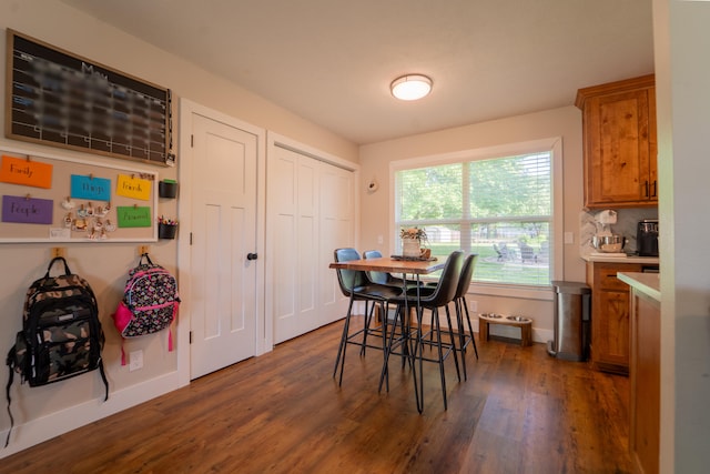 dining area featuring dark wood-type flooring and baseboards