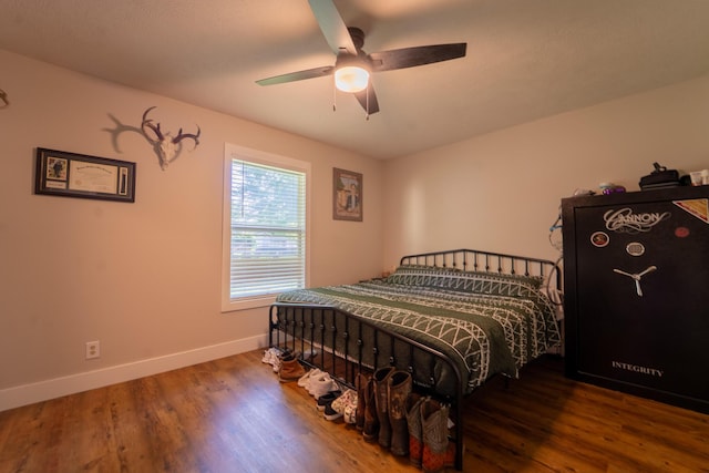 bedroom featuring wood finished floors, baseboards, and ceiling fan