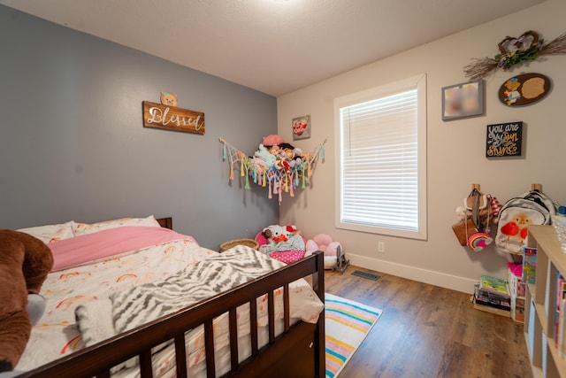 bedroom with baseboards and wood finished floors