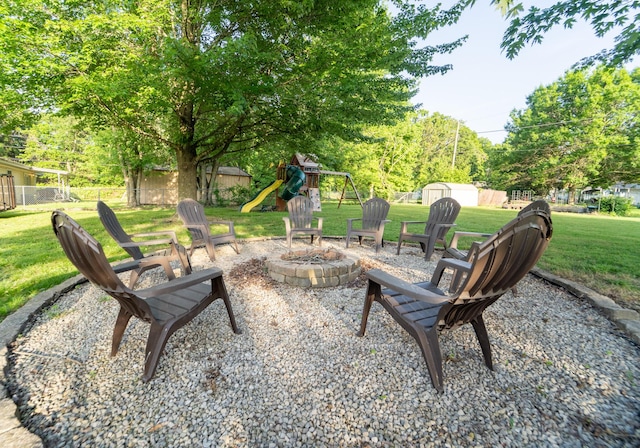 view of patio / terrace with a fire pit, a storage unit, an outdoor structure, and a playground