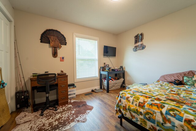 bedroom with wood finished floors and baseboards