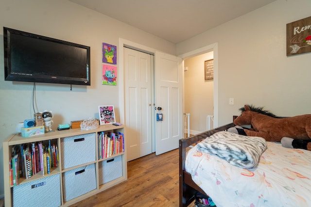bedroom with wood finished floors and a closet