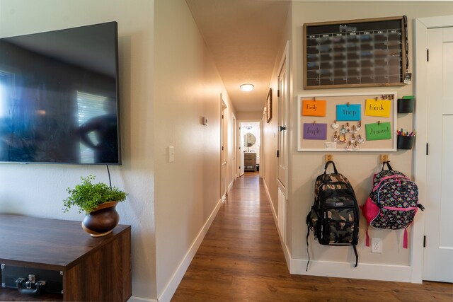 corridor with wood finished floors and baseboards