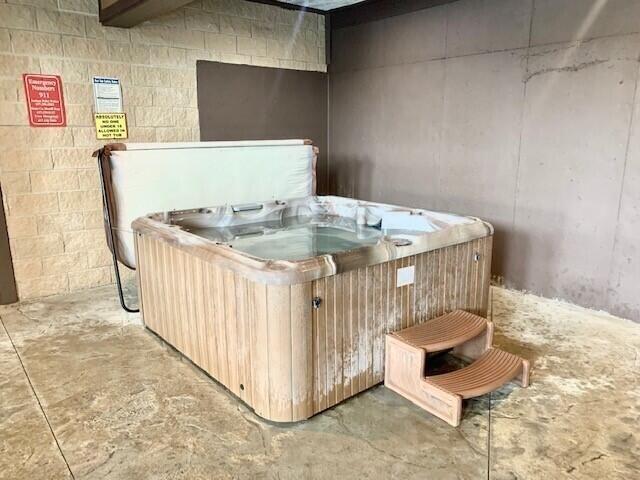miscellaneous room featuring a jacuzzi and concrete floors
