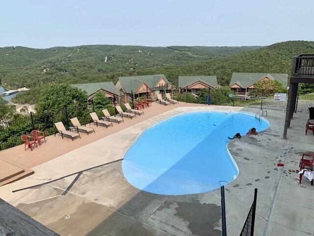 community pool featuring fence and a patio area