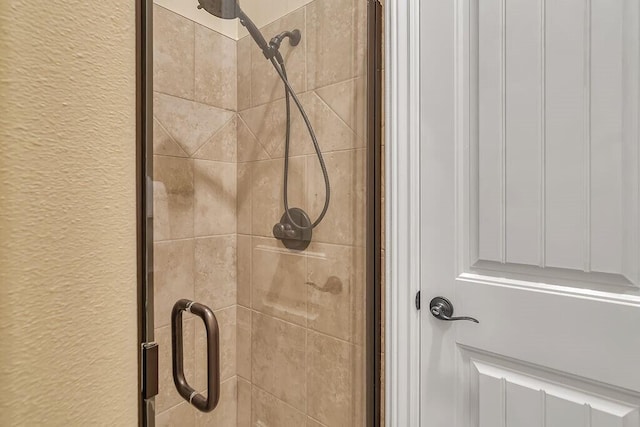 bathroom view of a stall shower and a textured wall