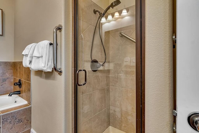 bathroom featuring a shower stall and a garden tub