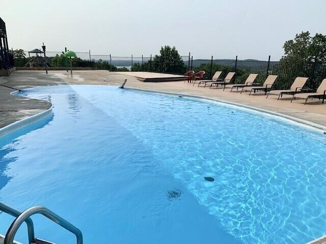community pool featuring fence and a patio area