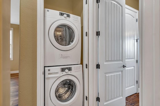 laundry room with estacked washer and dryer and wood finished floors