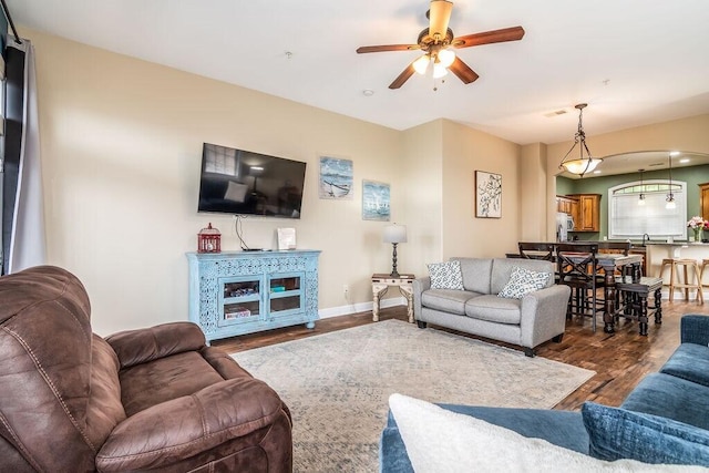 living room featuring a ceiling fan, wood finished floors, and baseboards