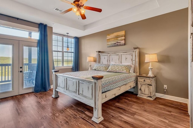 bedroom featuring access to outside, french doors, dark wood finished floors, and multiple windows