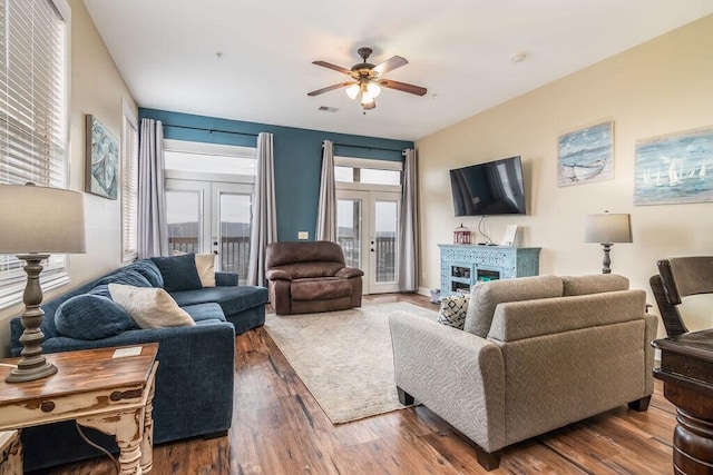 living room with ceiling fan, wood finished floors, a fireplace, and french doors