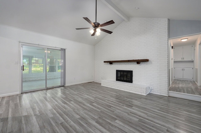 2857 E Linwood St, Springfield, MO 65804 - unfurnished living room featuring beamed ceiling, a ceiling fan, wood finished floors, a fireplace, and baseboards