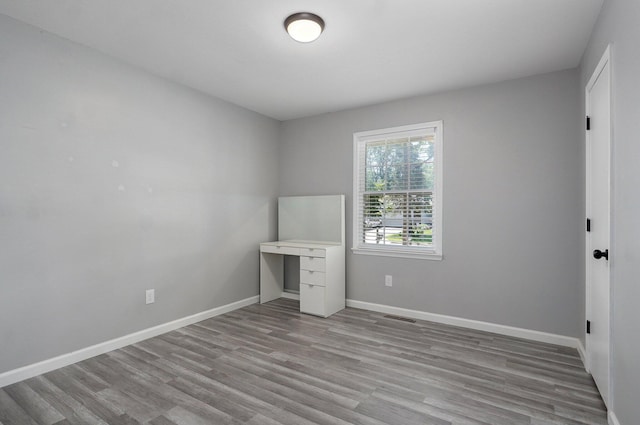 2857 E Linwood St, Springfield, MO 65804 - unfurnished bedroom featuring wood finished floors, baseboards, and an office area