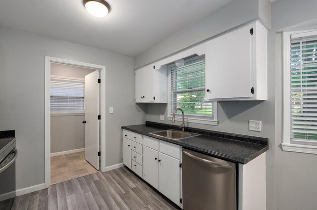 2857 E Linwood St, Springfield, MO 65804 - kitchen featuring a sink, dishwasher, white cabinets, dark countertops, and light wood-style flooring