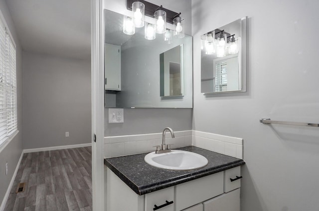 2857 E Linwood St, Springfield, MO 65804 - bathroom with wood finished floors, tasteful backsplash, and vanity