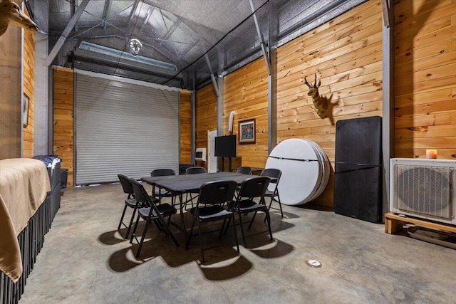 dining space featuring concrete floors, wooden walls, and heating unit