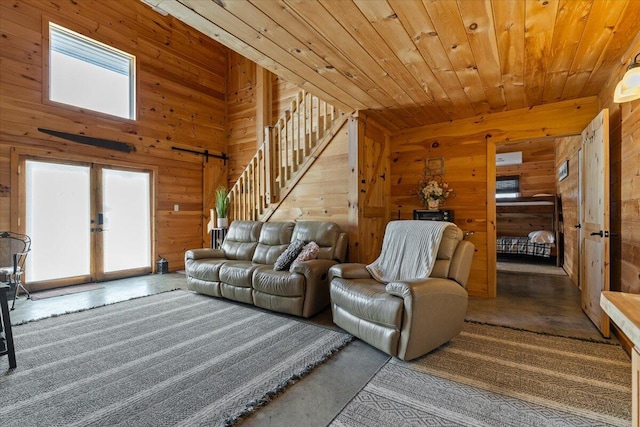 living room featuring wooden walls, stairway, wooden ceiling, and french doors