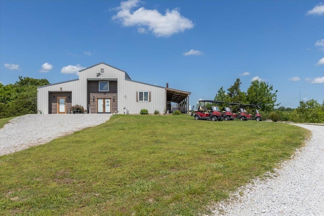 view of front of house featuring a front lawn, a garage, and a pole building