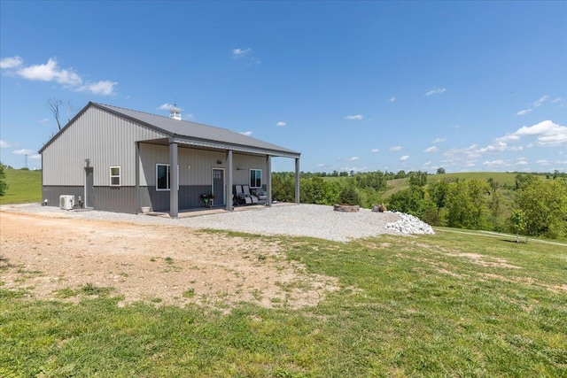rear view of property featuring a lawn and a patio area