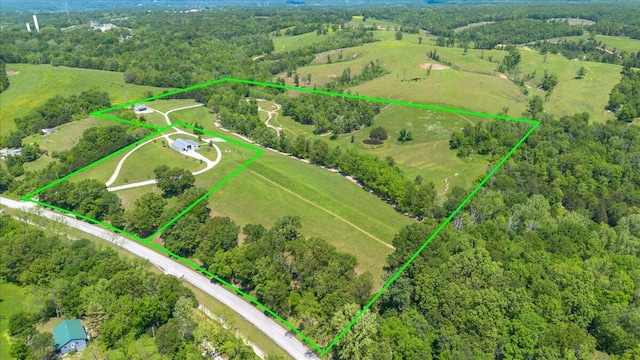 aerial view of sparsely populated area featuring property parcel outlined and a heavily wooded area