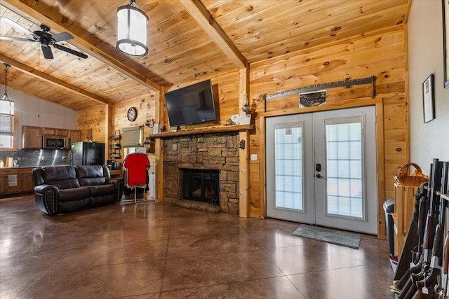 living room featuring wood walls, wooden ceiling, french doors, a stone fireplace, and a ceiling fan