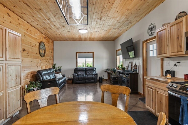 dining area with healthy amount of natural light, dark tile patterned floors, and wood ceiling