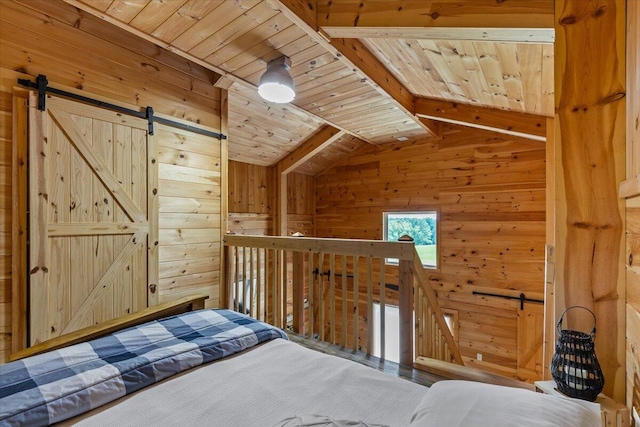bedroom featuring wooden walls, a barn door, and wood ceiling
