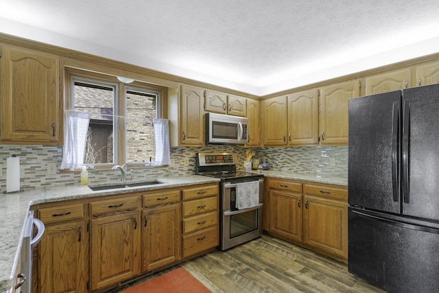 2515 S Laurel Ave, Springfield, MO 65807 - kitchen with appliances with stainless steel finishes, a sink, dark wood-style flooring, decorative backsplash, and brown cabinets