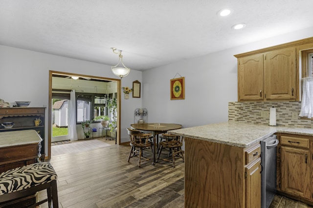 2515 S Laurel Ave, Springfield, MO 65807 - kitchen with decorative backsplash, a peninsula, dark wood finished floors, recessed lighting, and light stone countertops