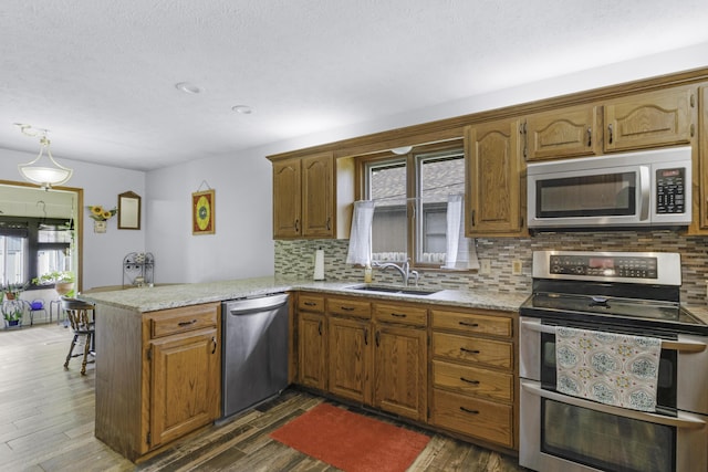 2515 S Laurel Ave, Springfield, MO 65807 - kitchen with stainless steel appliances, a sink, a peninsula, backsplash, and recessed lighting