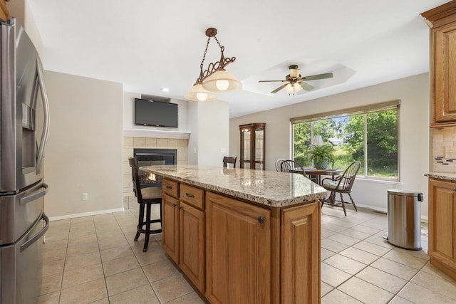 40 Overton Ct, Kimberling City, MO 65686 - kitchen with stainless steel fridge, light tile patterned floors, ceiling fan, baseboards, and a kitchen island