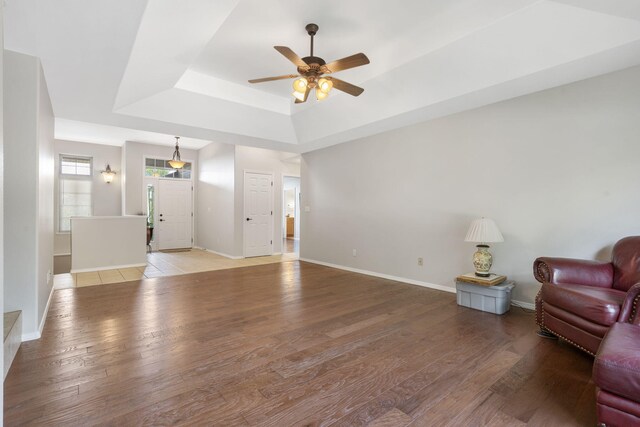 40 Overton Ct, Kimberling City, MO 65686 - living room featuring a tray ceiling, ceiling fan, light wood-style floors, and baseboards