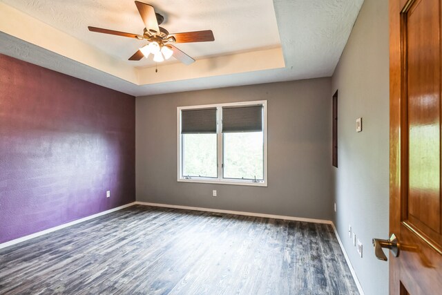 1888 S High Rdg, Nixa, MO 65714 - spare room with dark wood-type flooring, ceiling fan, a raised ceiling, and baseboards